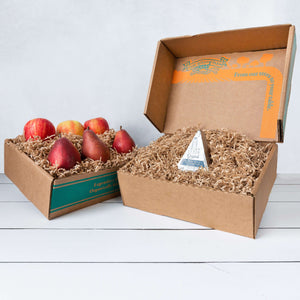 Two rustic craft gift baskets featuring juicy pears and crisp apples, and artfully packaged Point Reyes blue cheese.