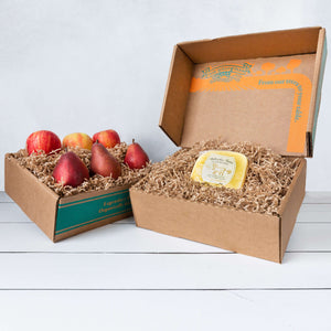 Two rustic craft gift baskets featuring juicy pears and crisp apples, and artfully packaged Bellwether Farms Carmody Cheese.