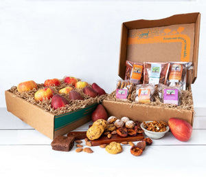 Two rustic raft gift boxes, one filled with crisp apples and juicy pears, and the other filled with artfully packaged Frog Hollow snacks.