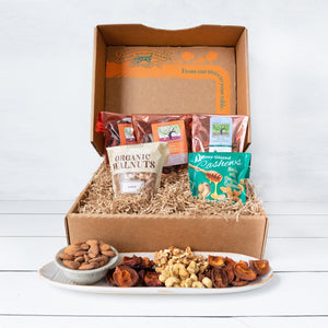A rustic craft gift basket featuring artfully packaged sun-dried fruit, almonds, walnuts, and cashews.
