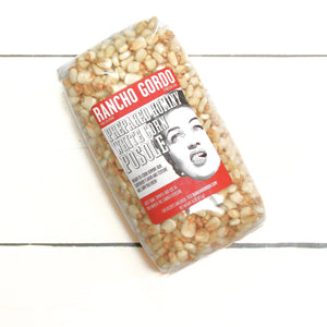 Hominy kernels in a sealed bag on a white flat lay.
