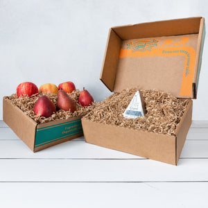 Two rustic craft gift baskets featuring juicy pears and crisp apples, and artfully packaged Point Reyes blue cheese.