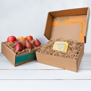 Two rustic craft gift baskets featuring juicy pears and crisp apples, and artfully packaged Bellwether Farms Carmody Cheese.