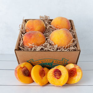 A close up image of fresh peaches in a rustic craft gift basket, showcasing their fuzzy skin and juicy texture.