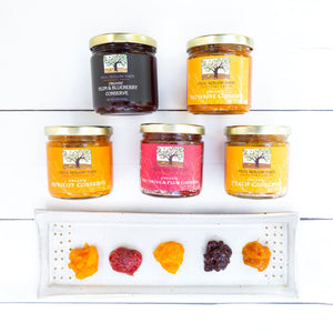 A visually appealing flat lay of a conserve collection, showcasing jars of colorful fruit preserves on a white background.