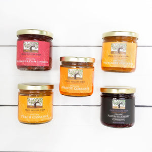 A visually appealing flat lay of a conserve collection, showcasing jars of colorful fruit preserves on a white background.