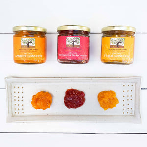 A visually appealing flat lay of a conserve collection, showcasing jars of colorful fruit preserves on a white background.